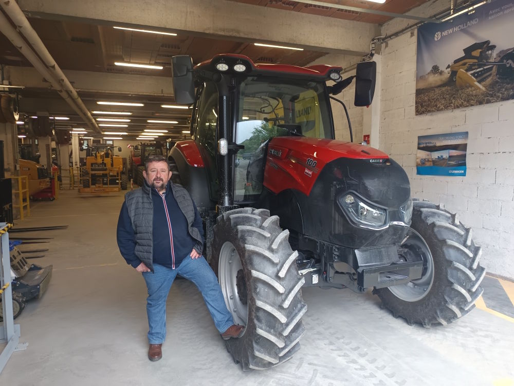 Portrait de Didier Reymondoux, debout à côté d'un tracteur